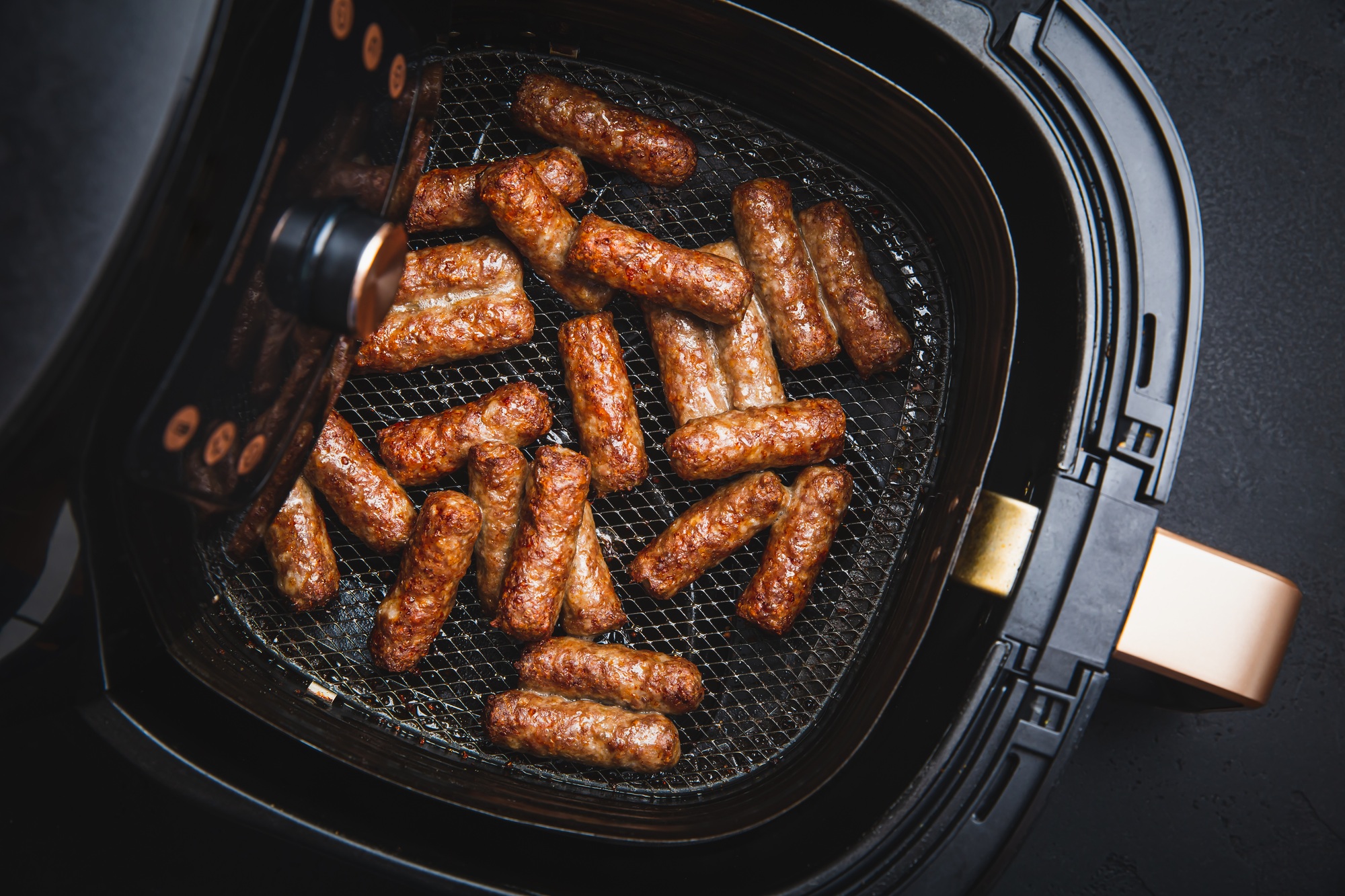 Kiełbasa w frytkownicy beztłuszczowej podana z musztardą i pieczywem.