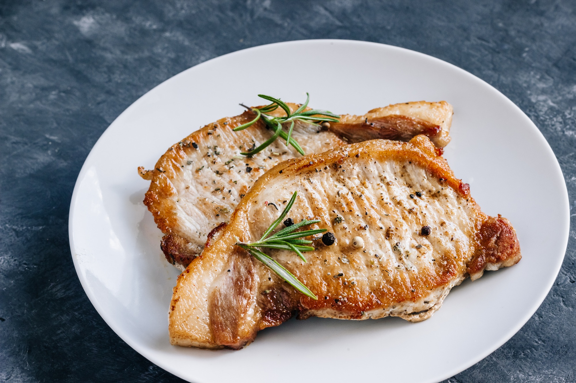 Pieczeń wieprzowa w frytkownicy beztłuszczowej podana z pieczonymi ziemniakami i warzywami.